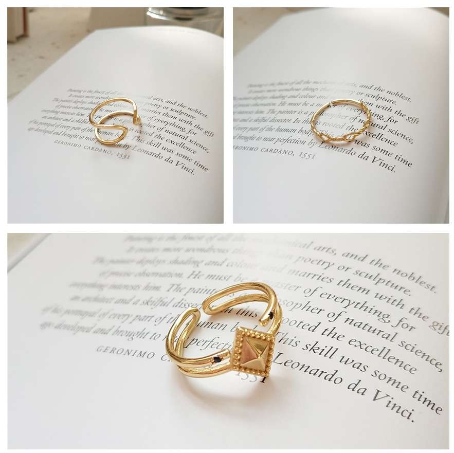 Gold ring with a square design on an open book