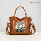 Brown leather handbag with decorative emblem on a light gray background