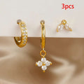 Three-piece gold hoop and dangle earrings with clear rhinestones, displayed on a white stand with a beige satin surface below. A red text overlay in the top right reads '3pcs'.