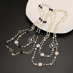 Pearl necklace with floral designs on a dark surface