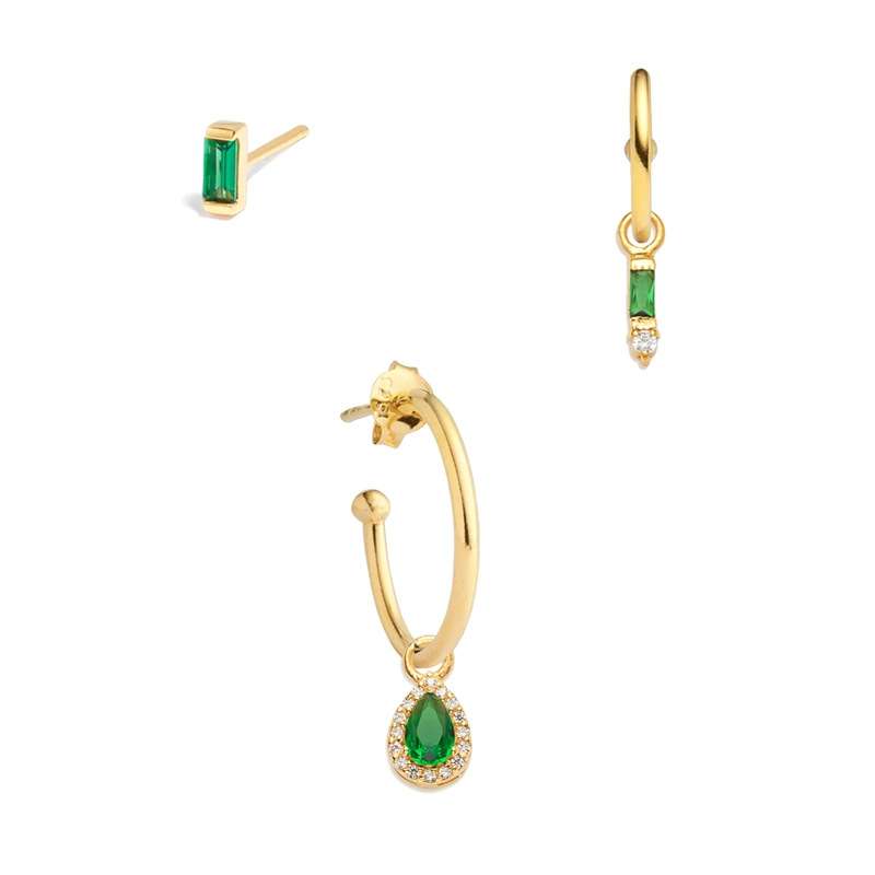 Gold hoop earrings with green gemstones on a white background
