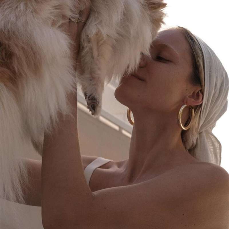 Woman kissing a dog with a blurred background