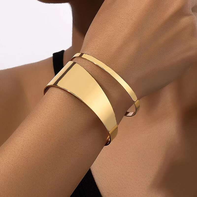 Gold bracelet on a person's wrist with a blurred background