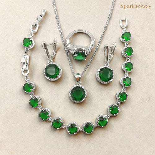 Jewelry set with green gemstones and silver accents on a beige background, featuring the brand 'SparkleSway'.