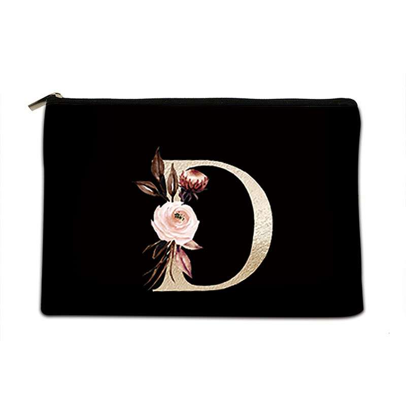 A black zippered cosmetic pouch featuring a large decorative gold letter 'D' embellished with a pink rose and dark brown leaves on the front, set against a plain white background.