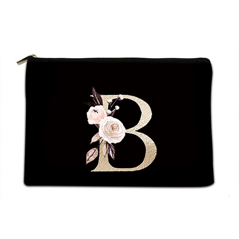A black zippered pouch featuring a large, textured gold letter 'B' embellished with light pink and white roses, set against a plain white background.