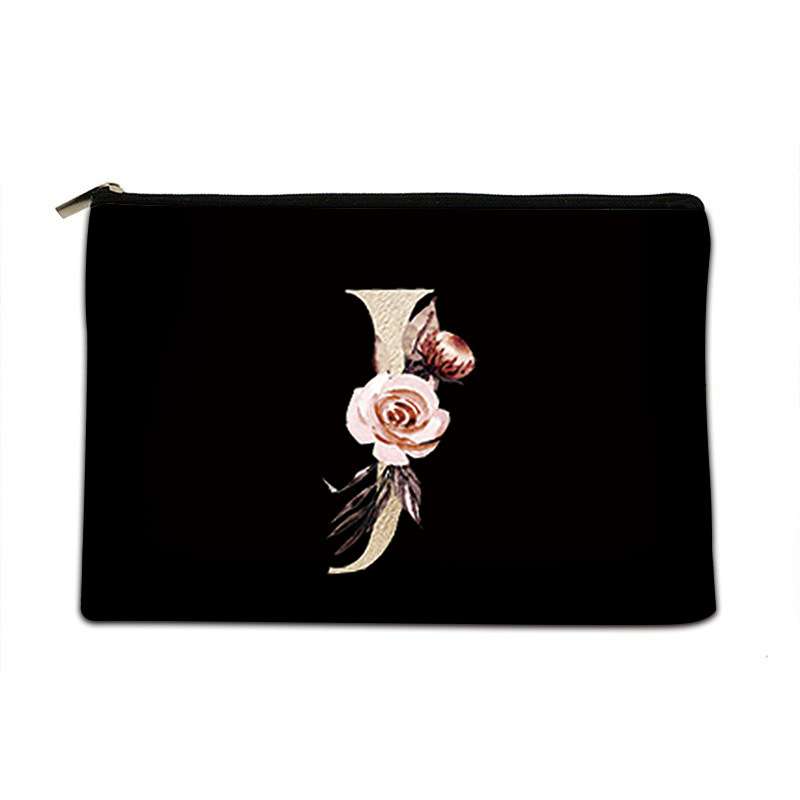 A black zippered pouch featuring a decorative embroidered letter 'J' embellished with pink roses, green leaves, and gold-toned details, shown against a plain white background.