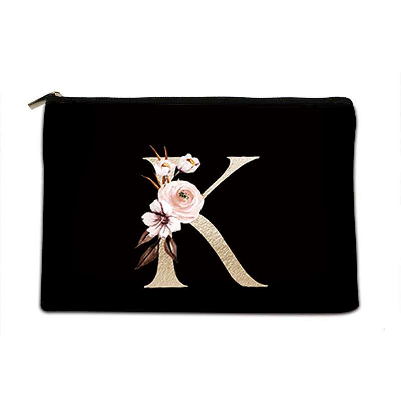 Black pouch with gold letter 'K' and floral design on a white background