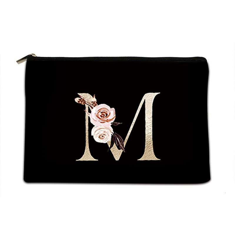 Black pouch with floral design and letter 'M' on a white background