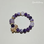 Purple beaded bracelet with decorative elements on a light gray background
