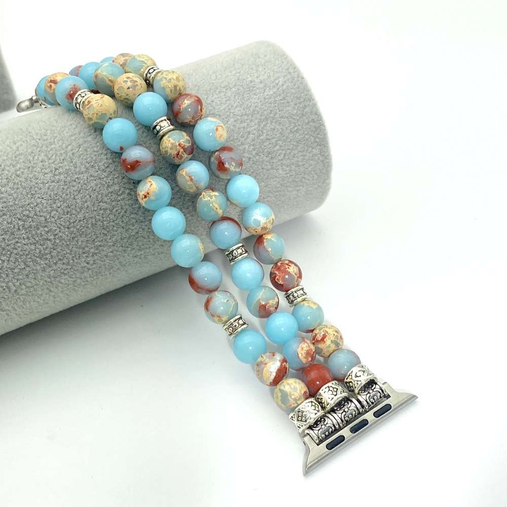Beaded Apple Watch band with decorative end piece on a white background