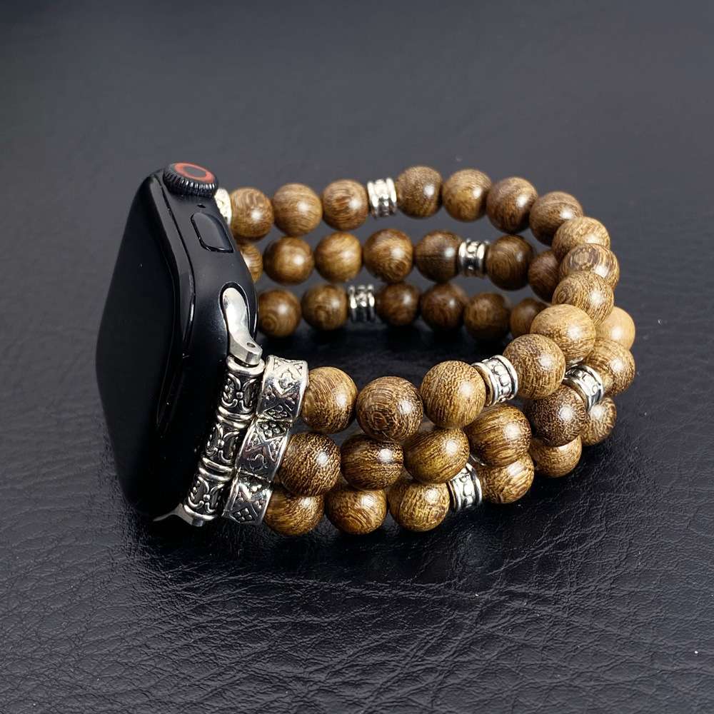 Wooden beaded bracelet with silver accents on a black leather surface
