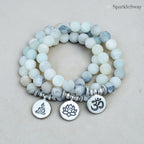 Stack of frosted beaded bracelets with symbolic charms on a light background, branded 'SparkleSway'.