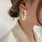 Pearl earring worn by a person with a neutral background