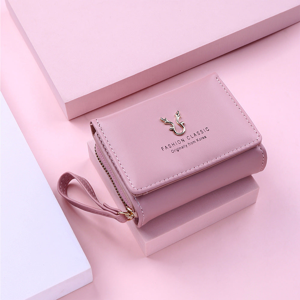 Pink wallet with a brand logo on a pink background