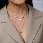 Close-up of a person wearing multiple chain necklaces with star pendants, branded 'SparkleSway